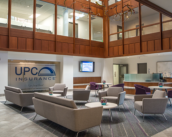 Employee standing by UPC logo on wall Employee standing by UPC logo on wall